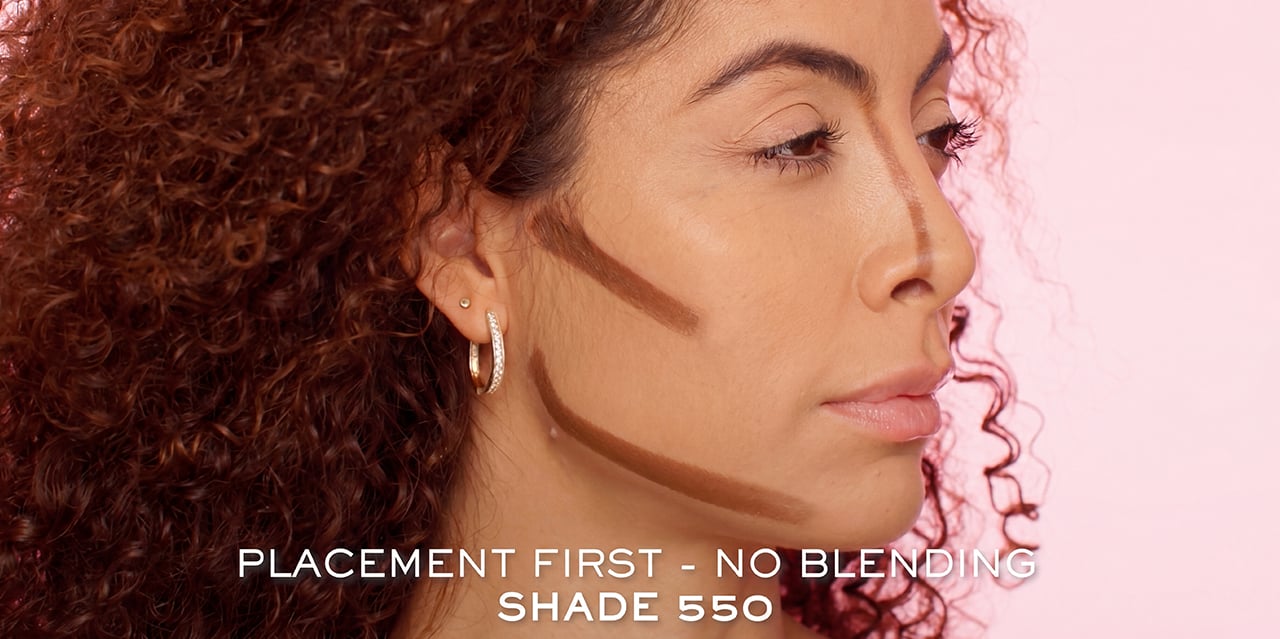 Shadow contour shade 550 placement on one side of model’s cheek, jaw, nose, and forehead for the bold and sculpted look